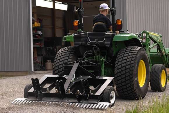 A man riding a tractor with a TR3 attached to it.