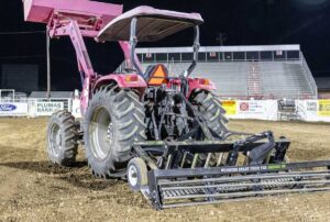 TR3 Rodeo Arena Drag by ABI Attachments, featuring a rolling basket for breaking up footing, adjustable hydraulic scarifiers, auto-leveling blade, 3/4″ hardened steel finish rake, and foam-filled stabilizing wheels for consistent arena grooming.
