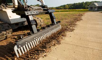 Skid steer loader attachment in usein the dirt.