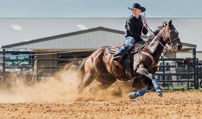 Trevor Brazile riding a horse in the outdoors.