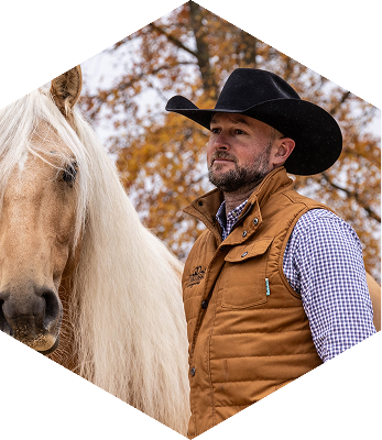 Dan James on a horse, looking off to the side.
