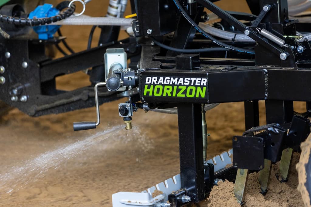 Close-up of the Dragmaster Horizon arena groomer showing its blades and frame.