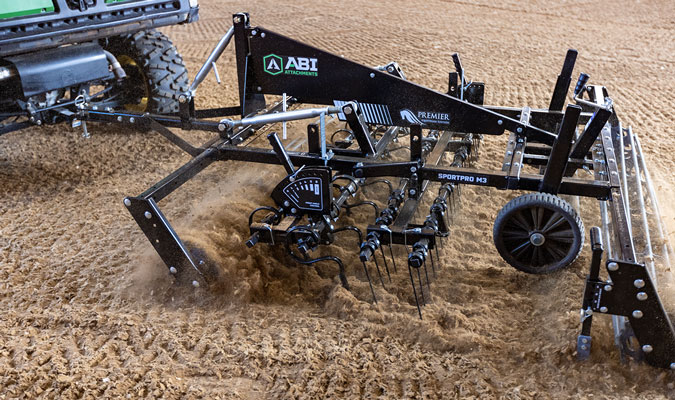 Arena drag attachment being dragged outside in a synthetic footing area.