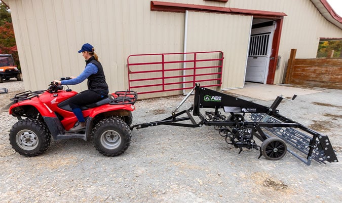 Red UTV dragging a Sportpro M1.