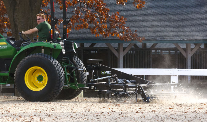 Synthetic drag tractor being used on a synthetic footing area.