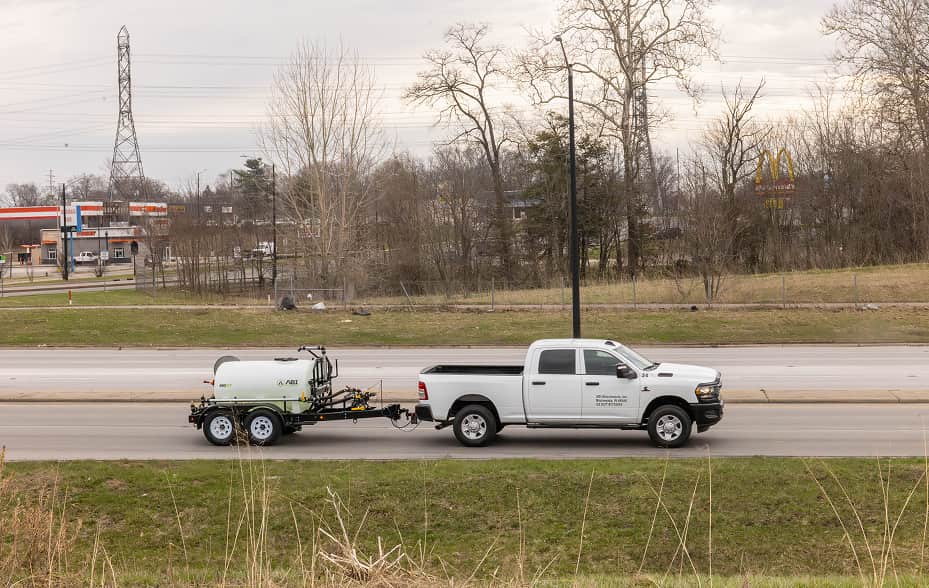 ABI 550 DOT Pro Water Trailer being towed by a pickup truck on a public road