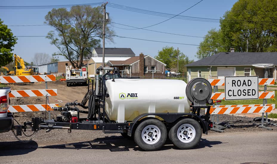 ABI 550 DOT Pro Water Trailer side view in front of a road construction site